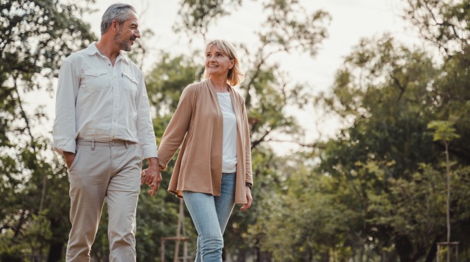 pareja de adultos de mediana edad caminando por un bosque