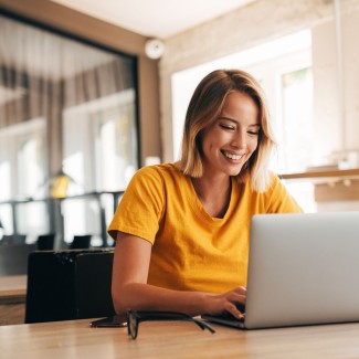 Mujer sonriendo al frente del computador