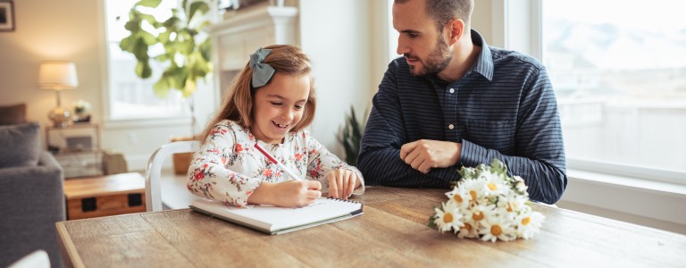 Padre ayudando a su hija con las tareas