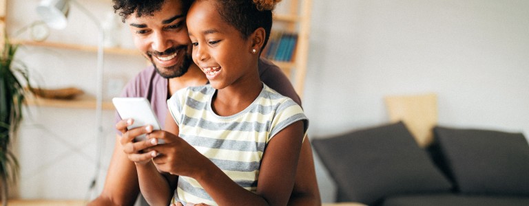 Padre revisando celular con su hija